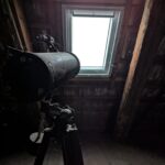 a telescope sitting on top of a metal pole